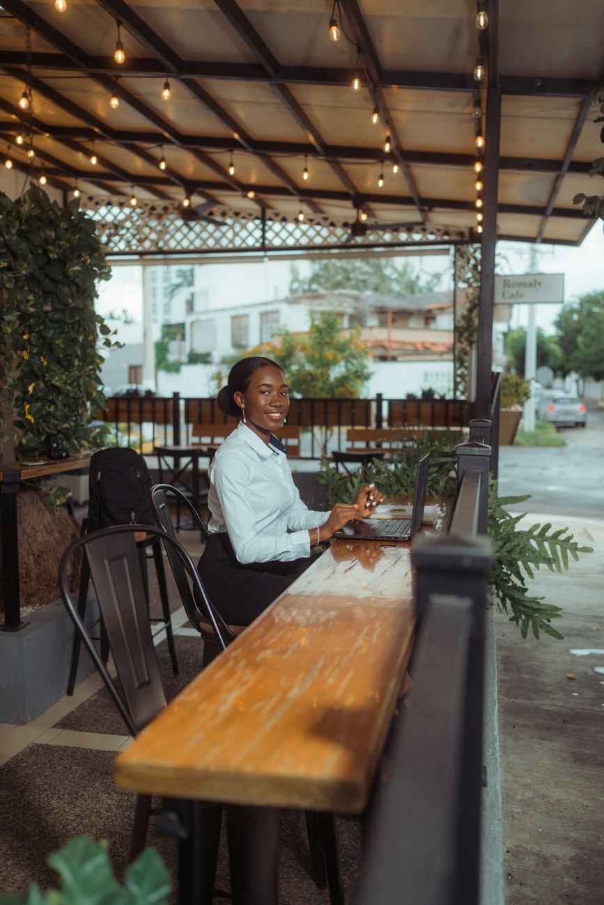 Woman working on her laptop at an outdoor cafe